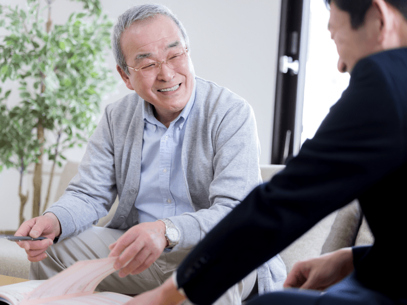 スーツの男性の説明を聞くシニア男性